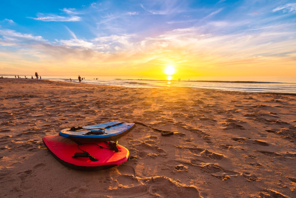 Bodyboards im Sand bei Sonnenuntergang am Strand