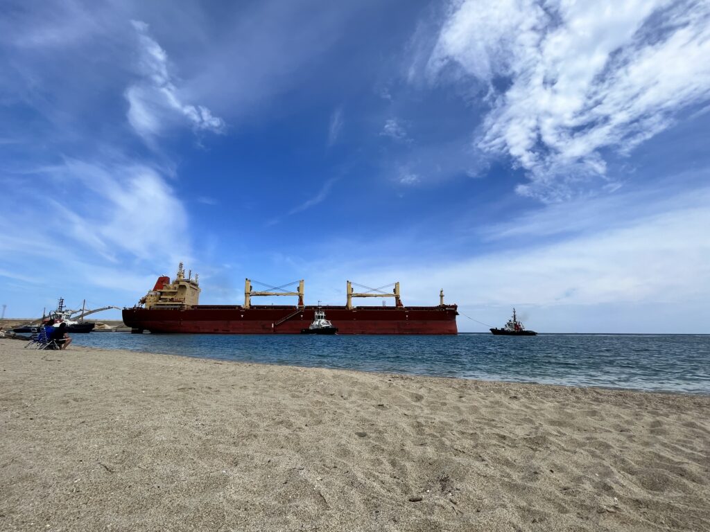 Leerer Strand in Andalusien im Herbst, Garrucha Strand mit großem Schiff im Hintergrund